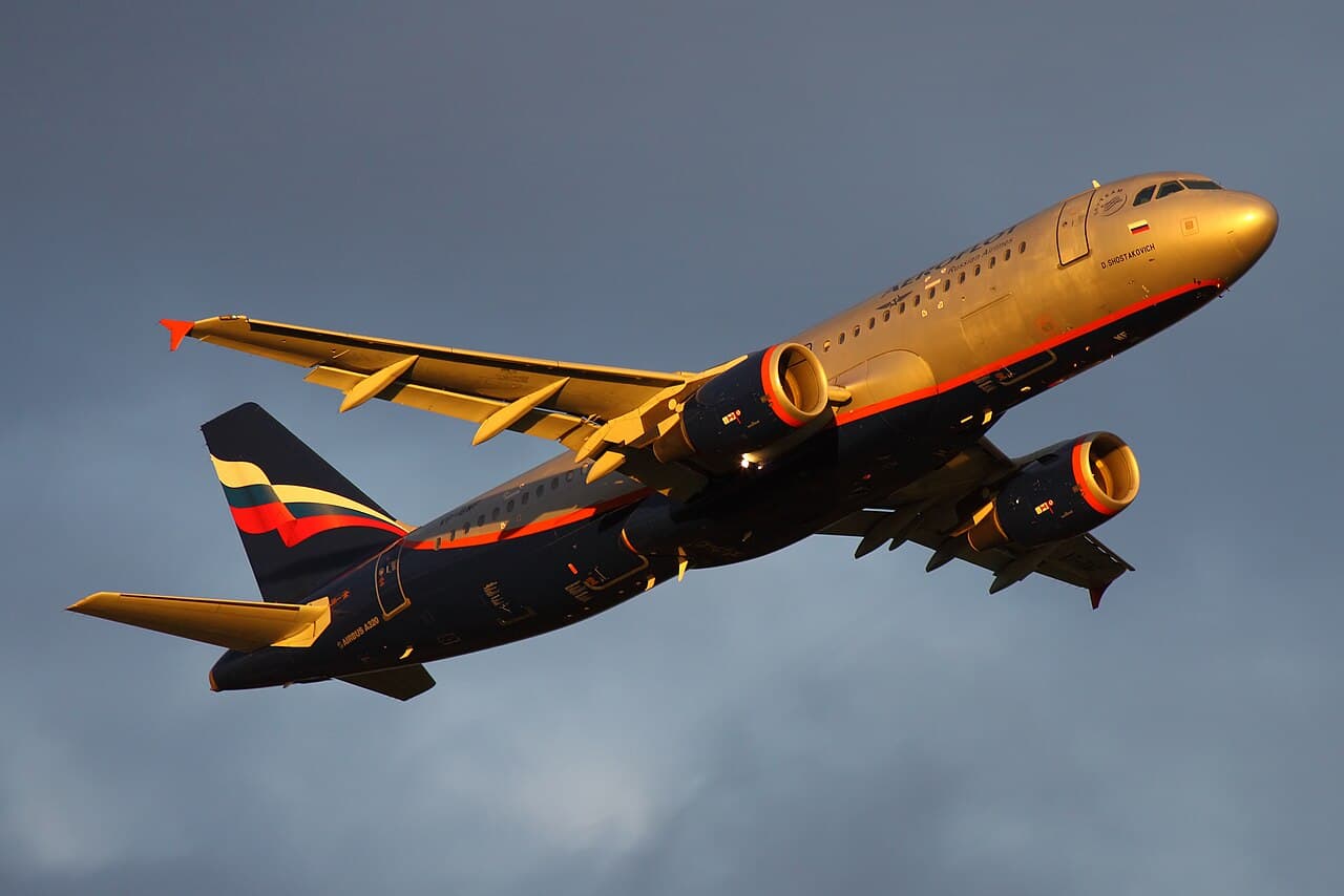 Airbus A320 family aircraft taking off at an international airport during daytime.