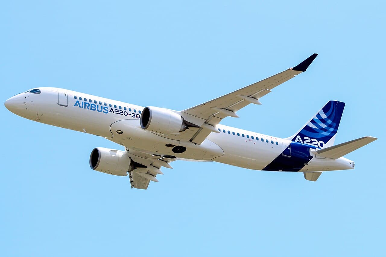 Crew member using virtual-reality headset and robotic arm to train on aircraft door procedures