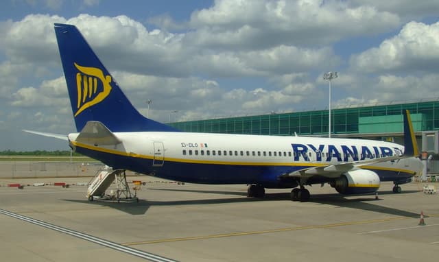 A Ryanair Boeing 737 taxiing at Barcelona-El Prat Airport in daylight.