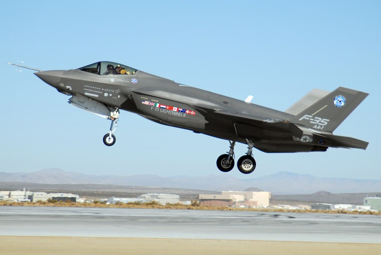 Lockheed Martin F-35 Lightning II in flight under cloudy sky with landing gear retracted